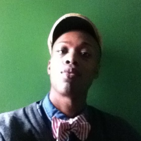 Kevin Ewing looking towards the camera wearing a cap and bow tie. 